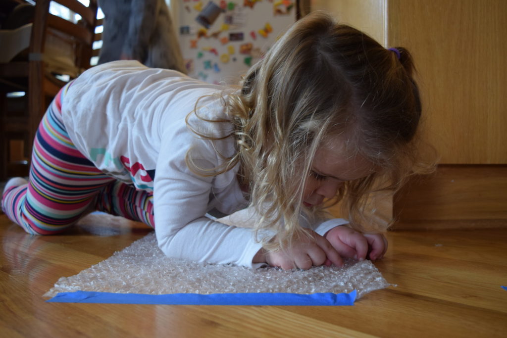 Homeschool preschool sounds theme and activities: learning about hearing through bubble wrap. Ten Thousand Hour Mama